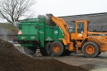 Een shovel vult eenvoudig de meststrooier met dikke fractie.